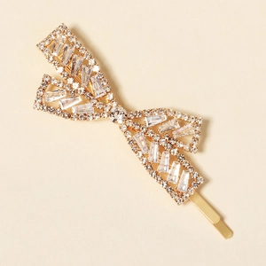 Close-up of elegant bow-shaped rhinestone hairpin with golden alloy and clear gems