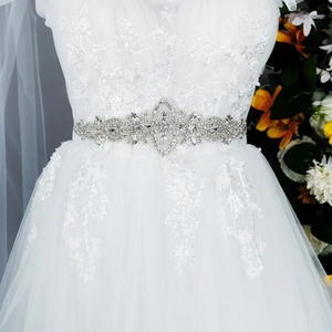 Détail d'une ceinture de mariée de luxe avec cristaux argentés sur robe de mariée en dentelle
