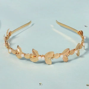 Dettaglio del cerchietto dorato con foglie di metallo, perle e texture naturale