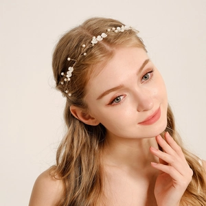 Vue détaillée du bandeau de mariée avec fleurs givrées et perles sur fil doré élégant