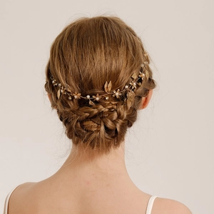 Bandeau mariée vintage feuilles dorées avec perles et strass sur une coiffure élégante