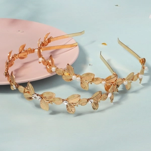 Eleganti cerchietti con foglie dorate decorati con perle e cristalli su sfondo azzurro