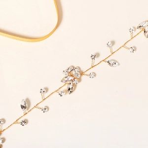 Détail d'une vigne de cheveux de mariée avec fil doré, strass et ruban de satin jaune