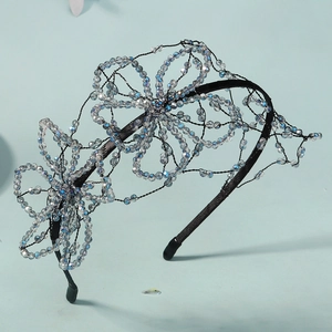 Detail of handcrafted blue crystal beads and woven flower design on a bridal headband