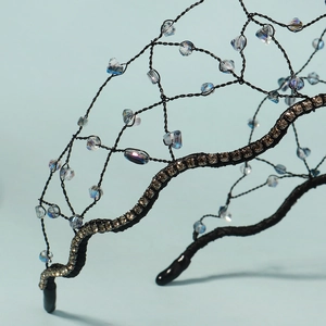 Détail macro d'un serre-tête de mariée tressé avec cristaux bleus et maille fine