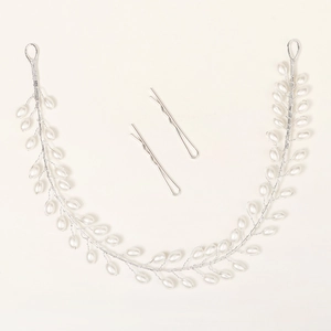 Détail macro du bandeau de mariée artisanal avec fils d'argent et perles blanches