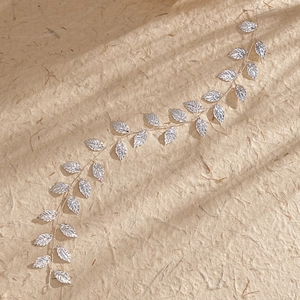 Détail macro de vigne de cheveux de mariée argentée avec feuilles métalliques sur papier texturé