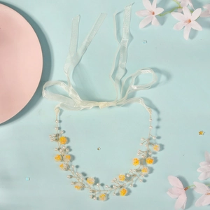 Détail du bandeau fleuri jaune fait main avec perles blanches et branches en fil doré