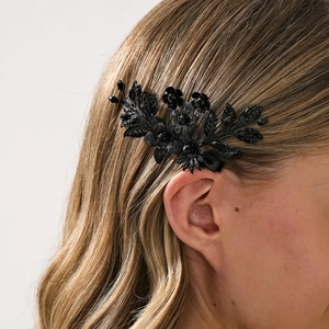 Detailaufnahme einer glänzenden schwarzen Vintage-Haarklammer mit feinen Blumenperlen
