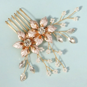 Detail of handmade bridal hair comb with gold metal leaves and pink resin flowers
