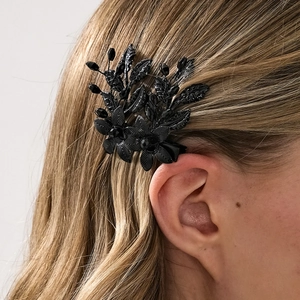 Nahaufnahme der schwarzen Metallblumen-Haarklammer mit facettierten Perlen am Haar