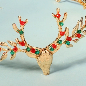 Gros plan du serre-tête renne de Noël doré avec des perles de cristal rouges et vertes