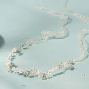 Vue macro détaillée du bandeau de mariée avec fleurs à la main et perles sur fond bleu clair