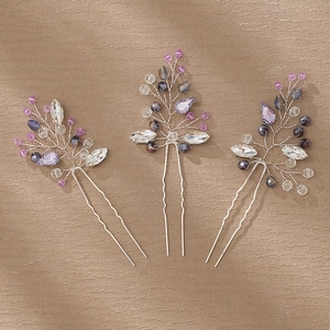 Close-up of handmade bridal hair pins with purple crystal beads and silver wire
