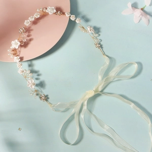 Détail du bandeau de mariée avec fleurs en céramique et perles blanches sur fil doré