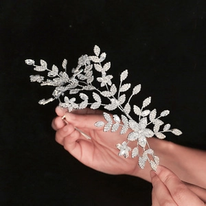 Dettaglio di pettine sposa in argento con cristalli scintillanti e motivi a foglia