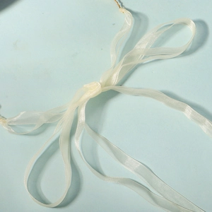 Détail d'un ruban en organza blanc noué en boucle pour accessoires de mariée