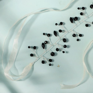 Détails d'un accessoire de cheveux en cristal noir fait main avec des rubans en organza