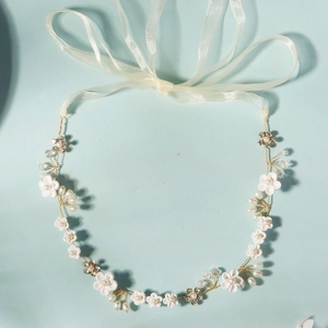 Serre-tête de mariée avec fleurs en céramique, perles et cristaux sur fond bleu