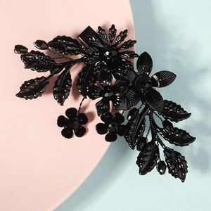 Detailaufnahme der schwarzen Metall-Haarklammer mit Blumen und Kristallperlen