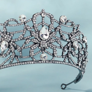 Detailed view of gunmetal spider crown with sparkling crystals and web pattern