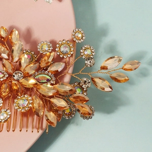 Detail of handcrafted golden bridal hair comb with amber crystals and rhinestones