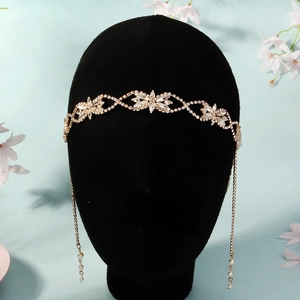 Détail du bandeau de mariée avec strass, franges dorées et perles sur un présentoir