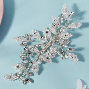 Détail d'un peigne à cheveux de mariée avec fil d'argent, perles blanches et cristaux