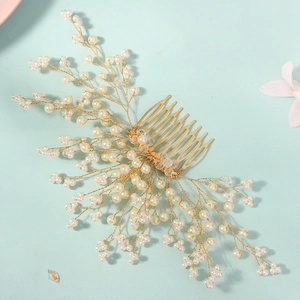 Close-up of golden bridal hair comb with elegant crystals and white pearls for weddings