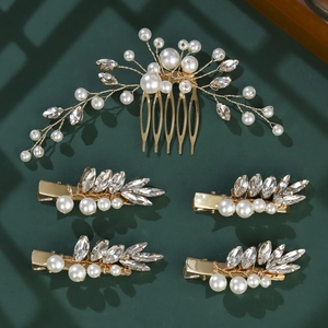 Elegant gold bridal hair comb set with white pearls and crystals on dark background