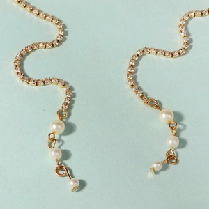 Vue macro de strass dorés et de perles blanches sur un ensemble de bijoux de mariée