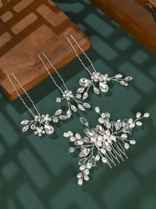 Detail of silver bridal hair comb set with white pearls and crystals on vintage wood