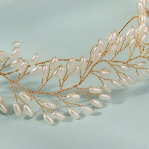 Detail eines Brauthaarschmucks aus Golddraht mit künstlichen Perlen auf blauem Hintergrund