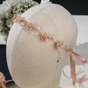 Detail of bridal headband with pink flowers, pearls, crystals and gold wire elements