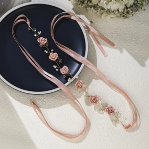 Detail of pink handmade ribbon headband with silk roses, white pearls and gold wire