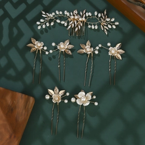 Detail of 7-piece gold floral bridal hair set with white pearls and metal leaves