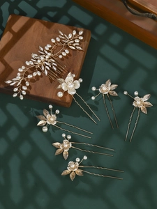 Detail of 7-piece gold bridal hair pin set with white pearls and leaf motifs