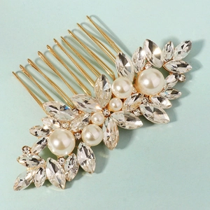 Macro detail of bridal hair comb with marquise rhinestones and white pearls on gold base