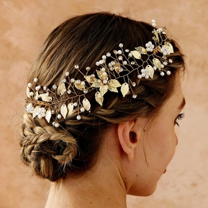Dettaglio del pettine per capelli dorato con perle e cristalli su un'elegante acconciatura
