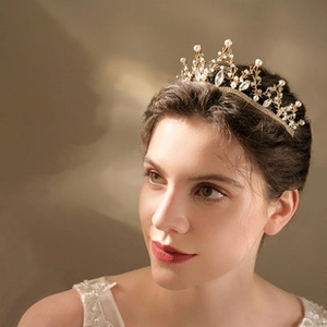 Close-up of luxury bridal crown with intricate gold branches, white pearls and clear crystals