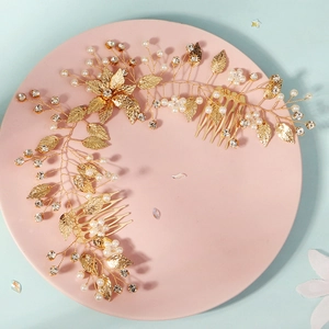 Dettaglio del pettine da sposa dorato con perle bianche e strass scintillanti