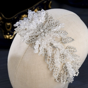 Close-up of handmade bridal headband with crystal beads and silver leaf details