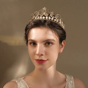 Detail of elegant gold bridal crown featuring white pearls and intricate filigree metalwork