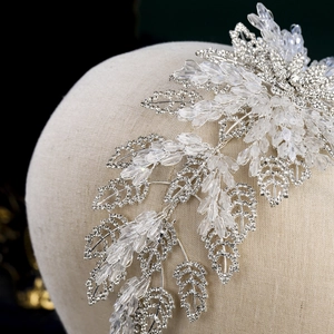 Close-up of luxury crystal bridal headband with silver metal leaves and sparkling rhinestones