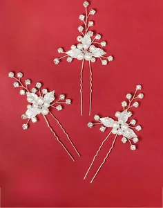 Dettaglio macro di forcine per capelli con foglie d'argento e perle per la sposa