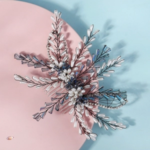 Détail d'un peigne à cheveux de mariée avec perles blanches et cristaux bleus