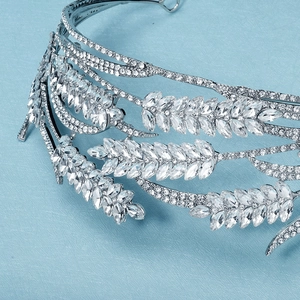 Macro view showing shimmering clear rhinestones and leaf pattern on silver bridal tiara