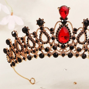 Detail of vintage gold crown featuring red teardrop gems and black crystal settings