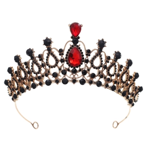 Close-up of vintage gold tiara with red teardrop gems and black rhinestones