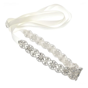 Détail du motif floral en strass fait main sur une ceinture de mariée en satin blanc
